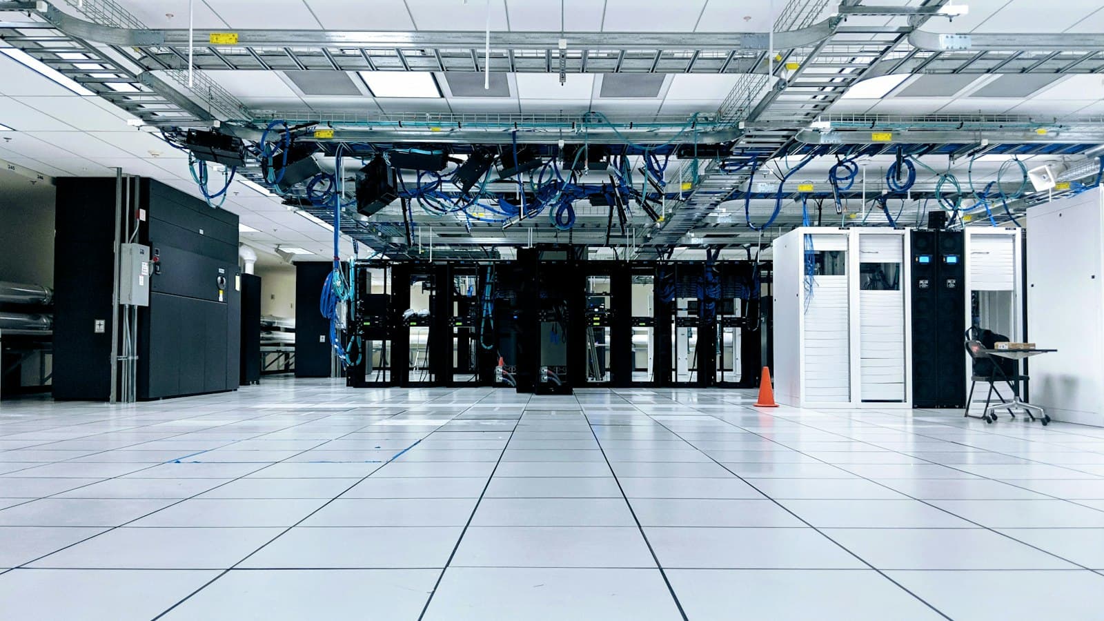 Spacious data centre floor with rows of server cabinets and overhead cable trays.